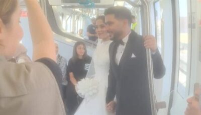 عروسان بملابس الزفاف الرسمية يحتفلان بزفافهما على متن أحد قطارات المونوريل
